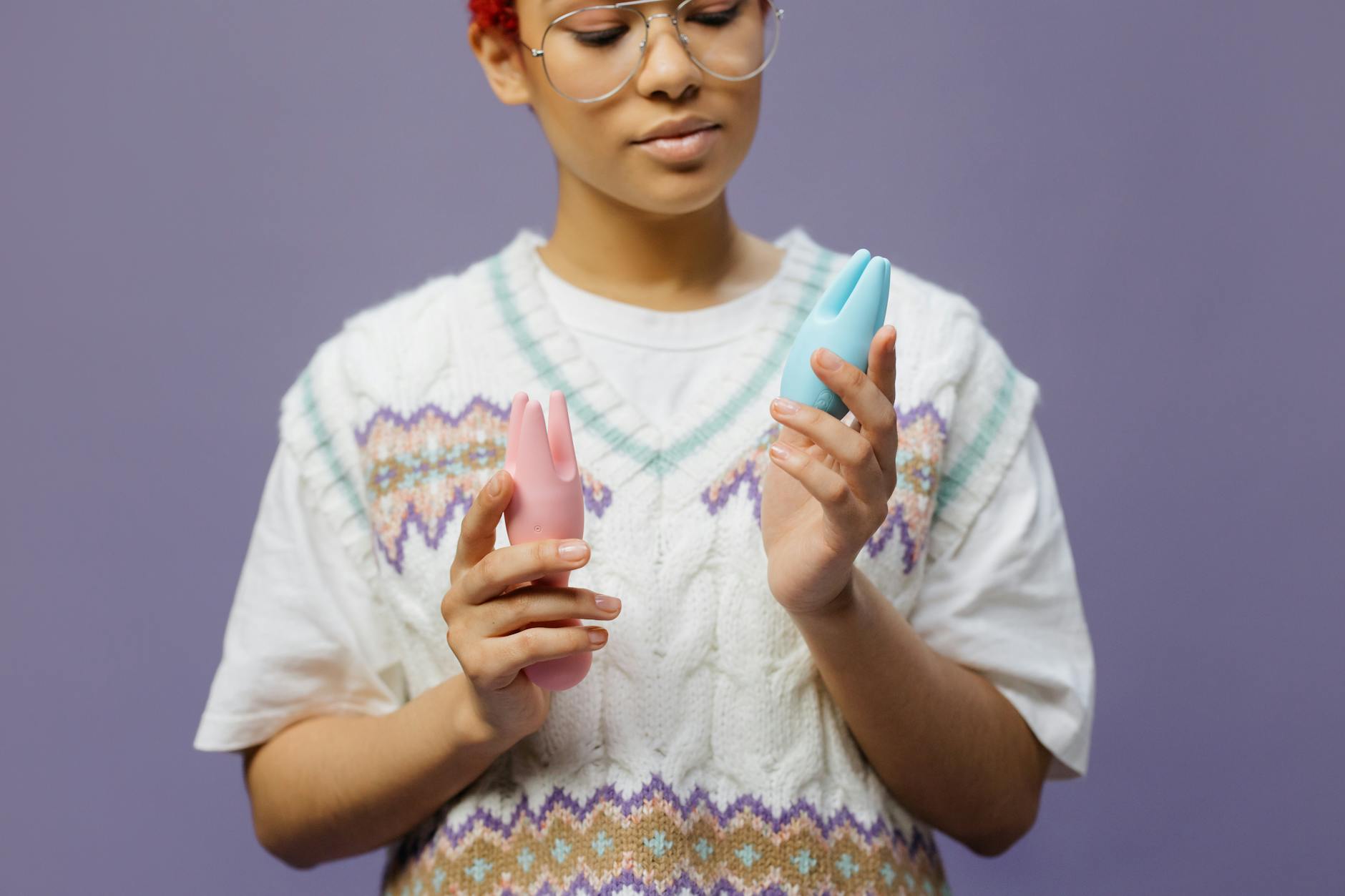 Woman holding colorful silicone vibrators, representing clitoral pleasure tools for managing pelvic tension
