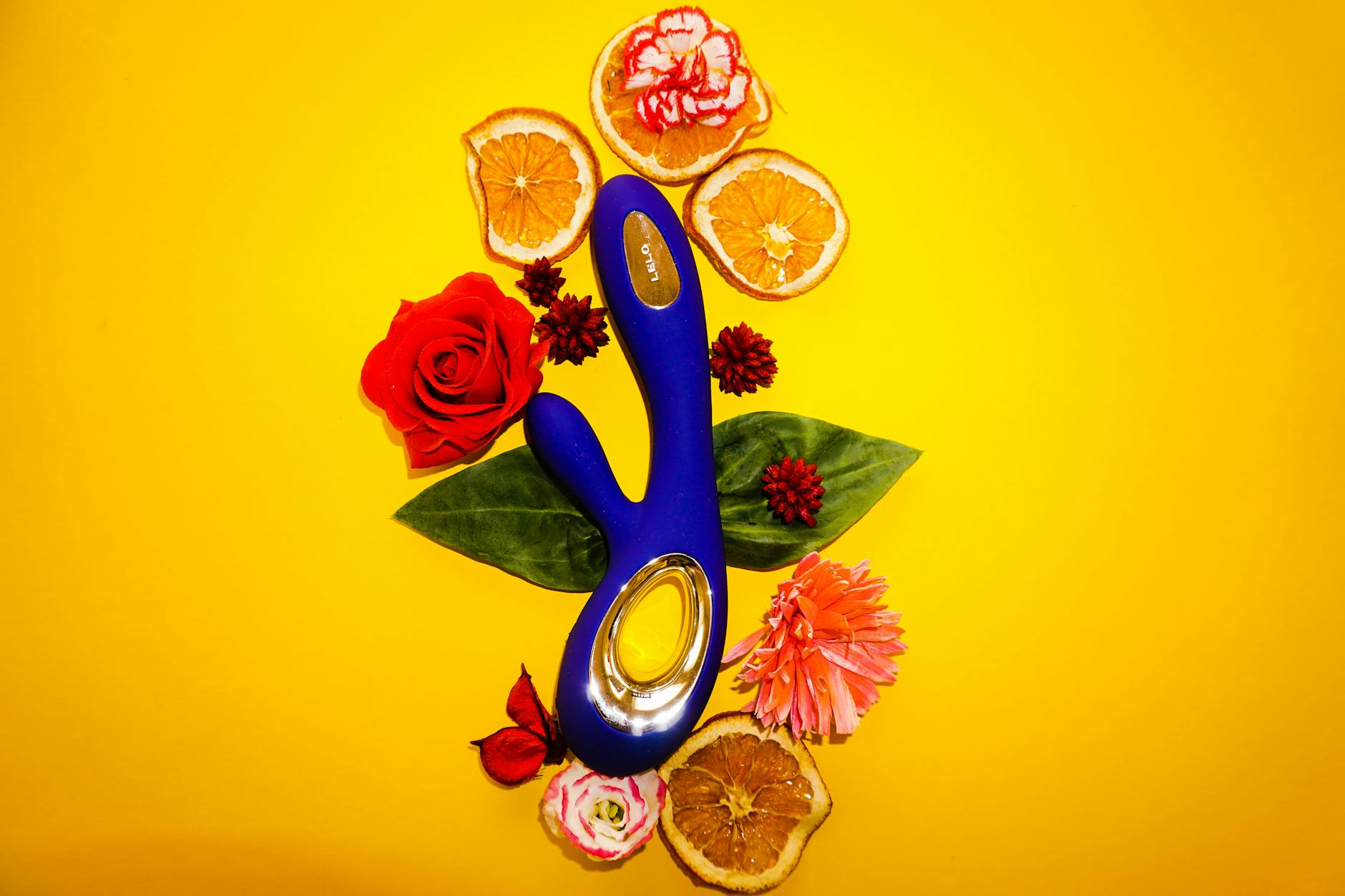 Hands holding and arranging colorful silicone clitoral vibrators on a table